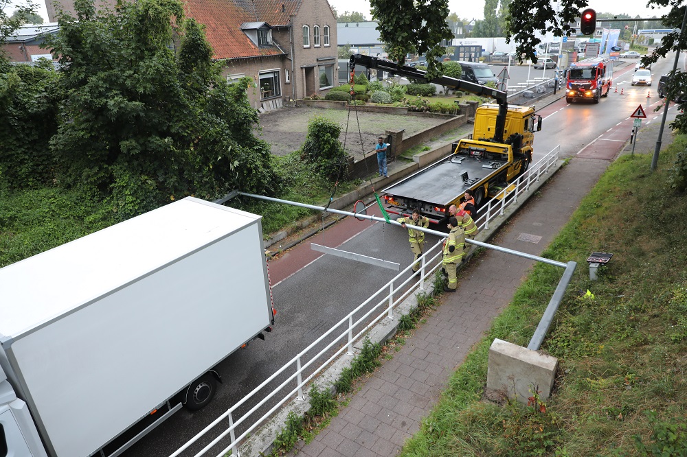 Bakwagen komt vast te zitten onder waarschuwingsbord
