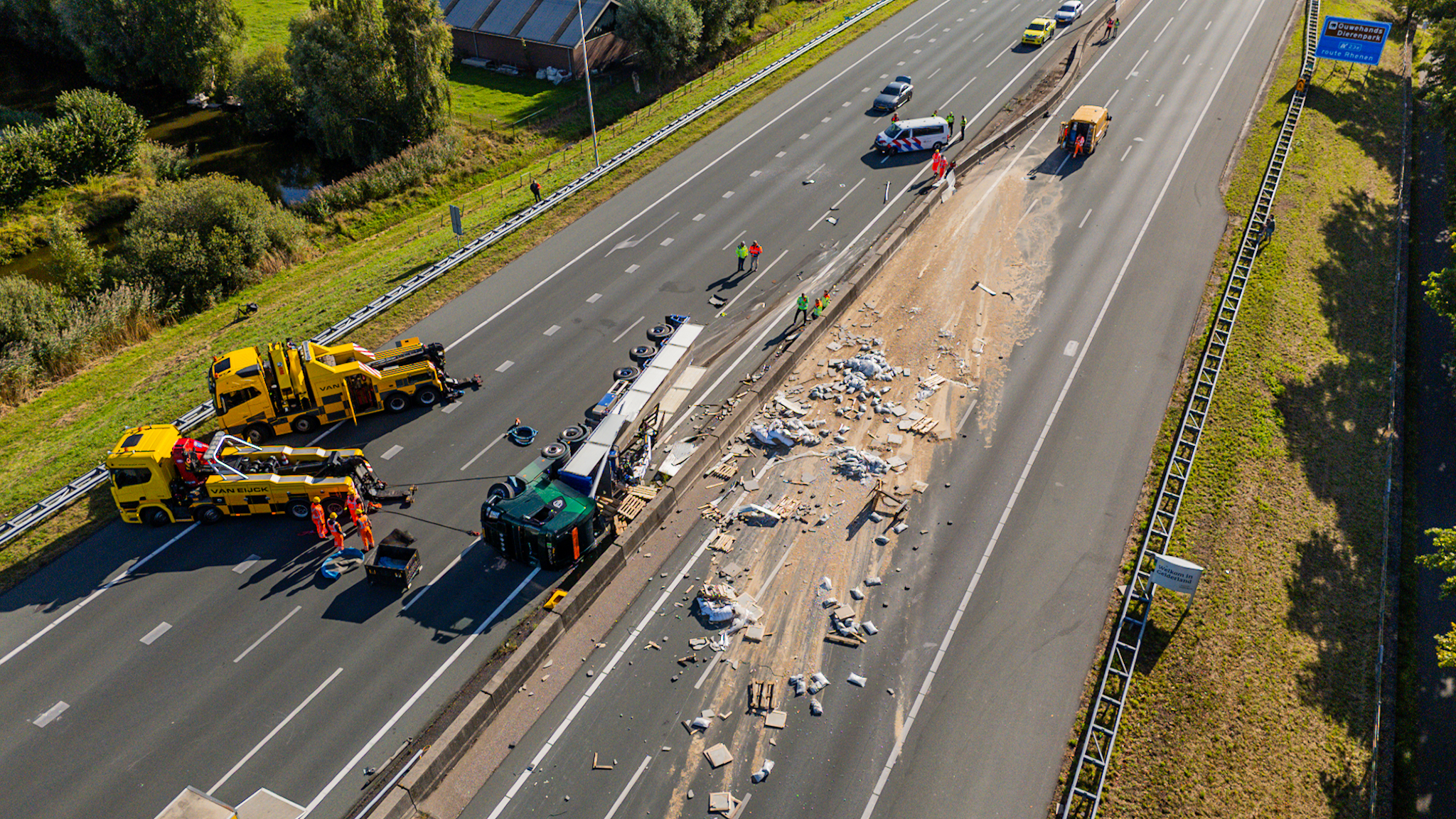 Lading op het wegdek na gekantelde vrachtwagen op snelweg