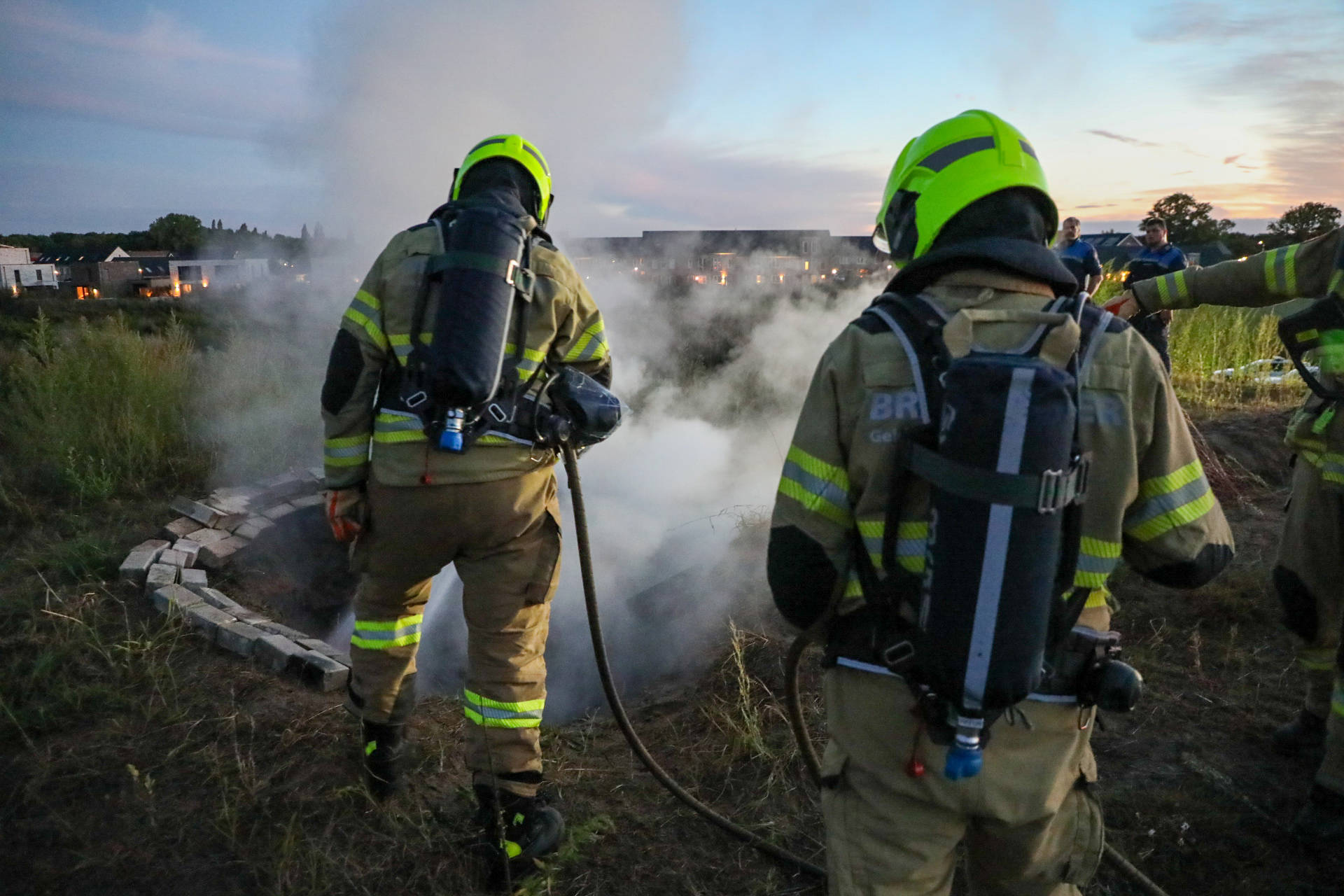 Brandweer blust afvalbrand op zandbult in nieuwbouwwijk