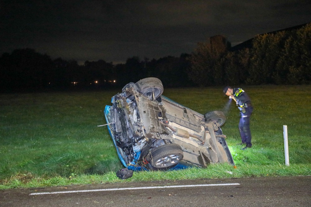Auto op z’n kant in sloot, bestuurster gewond