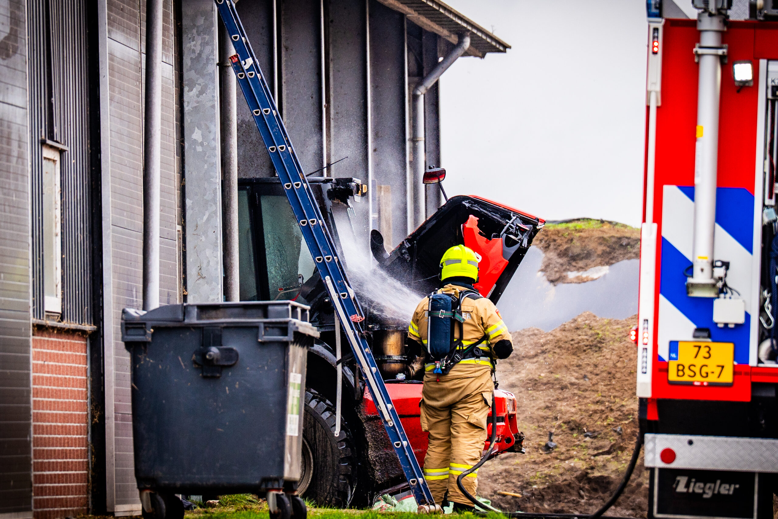 Landbouwvoertuig vat vlam in loods