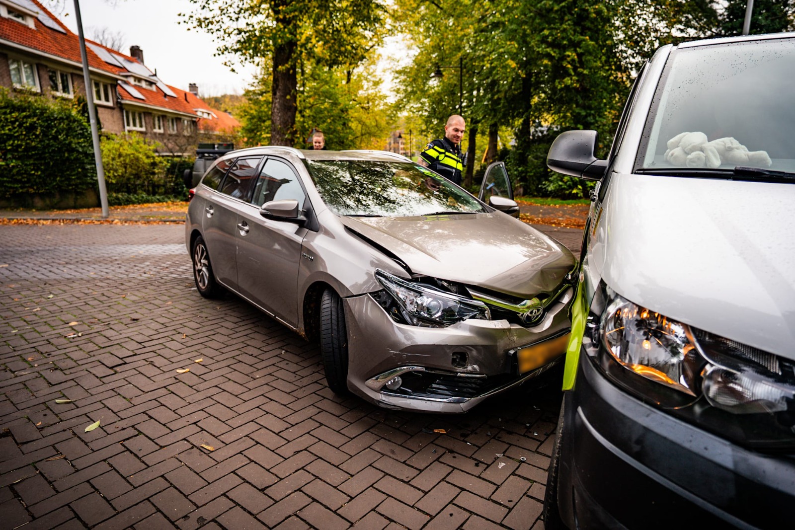 Auto en busje botsen op kruising, bestuurder gecontroleerd door ambulance