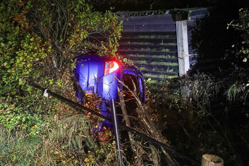 Automobilist slaat over de kop en belandt in tuin