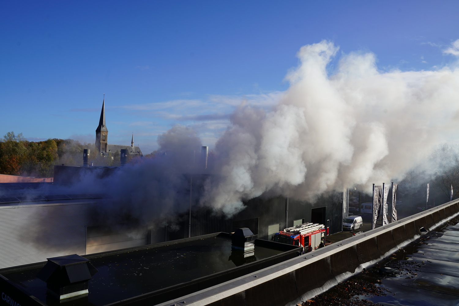 Donkere rookwolken door brand bij autoschadebedrijf