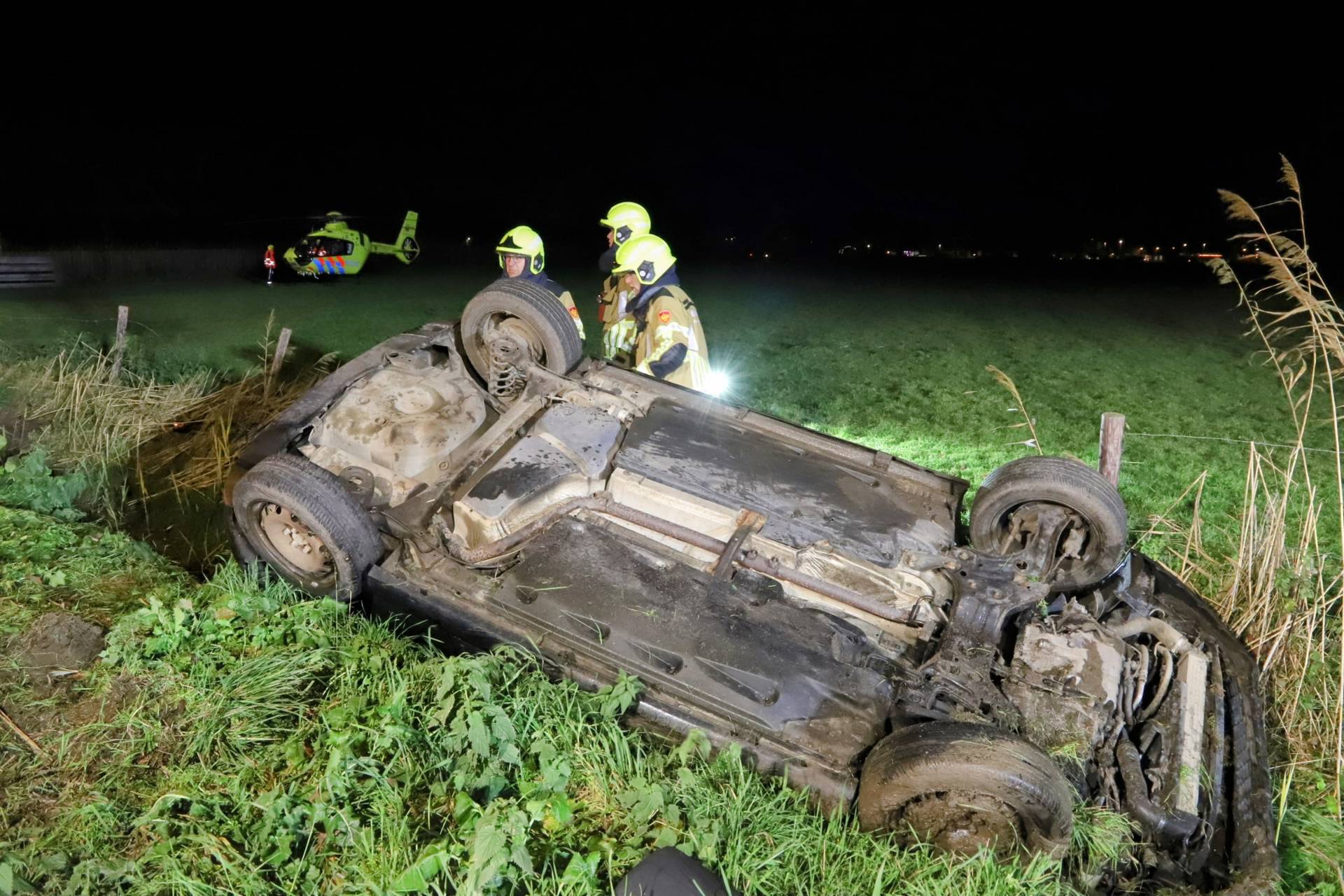 Man bekneld in over de kop geraakte auto in de sloot