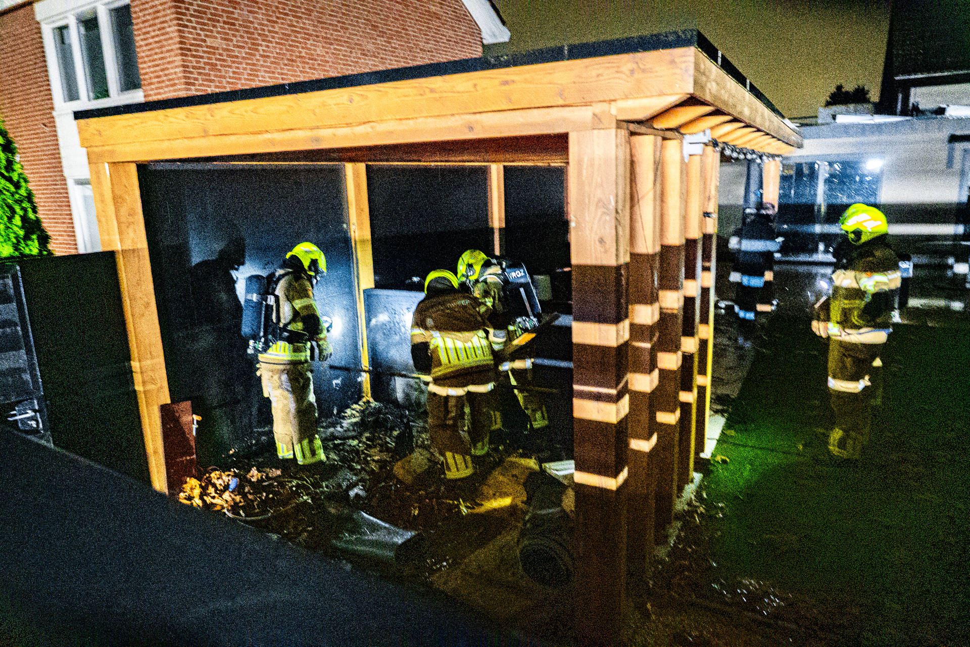 Brand onder overkapping achter woning