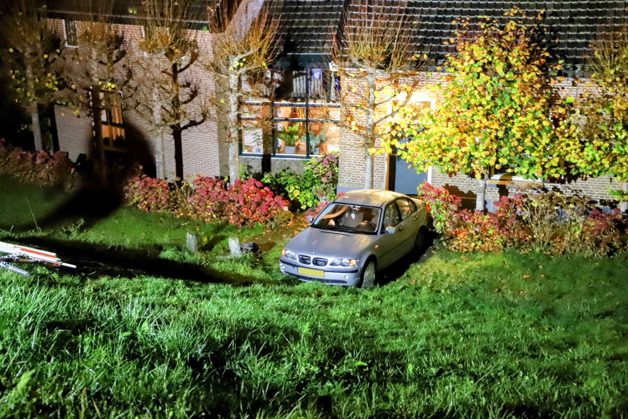 Auto raakt van dijk en komt voor woning tot stilstand