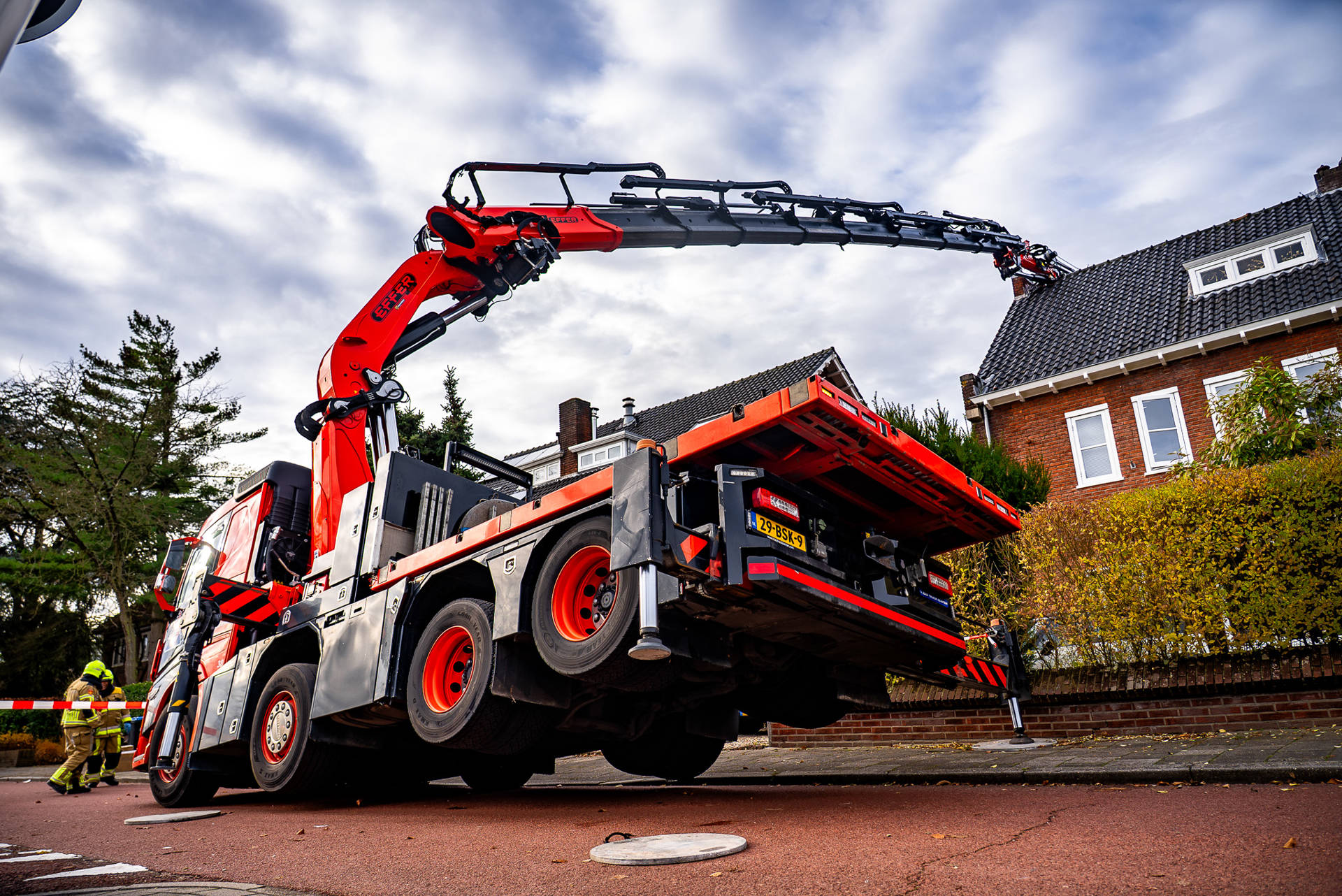 Hijskraan valt om tegen woning