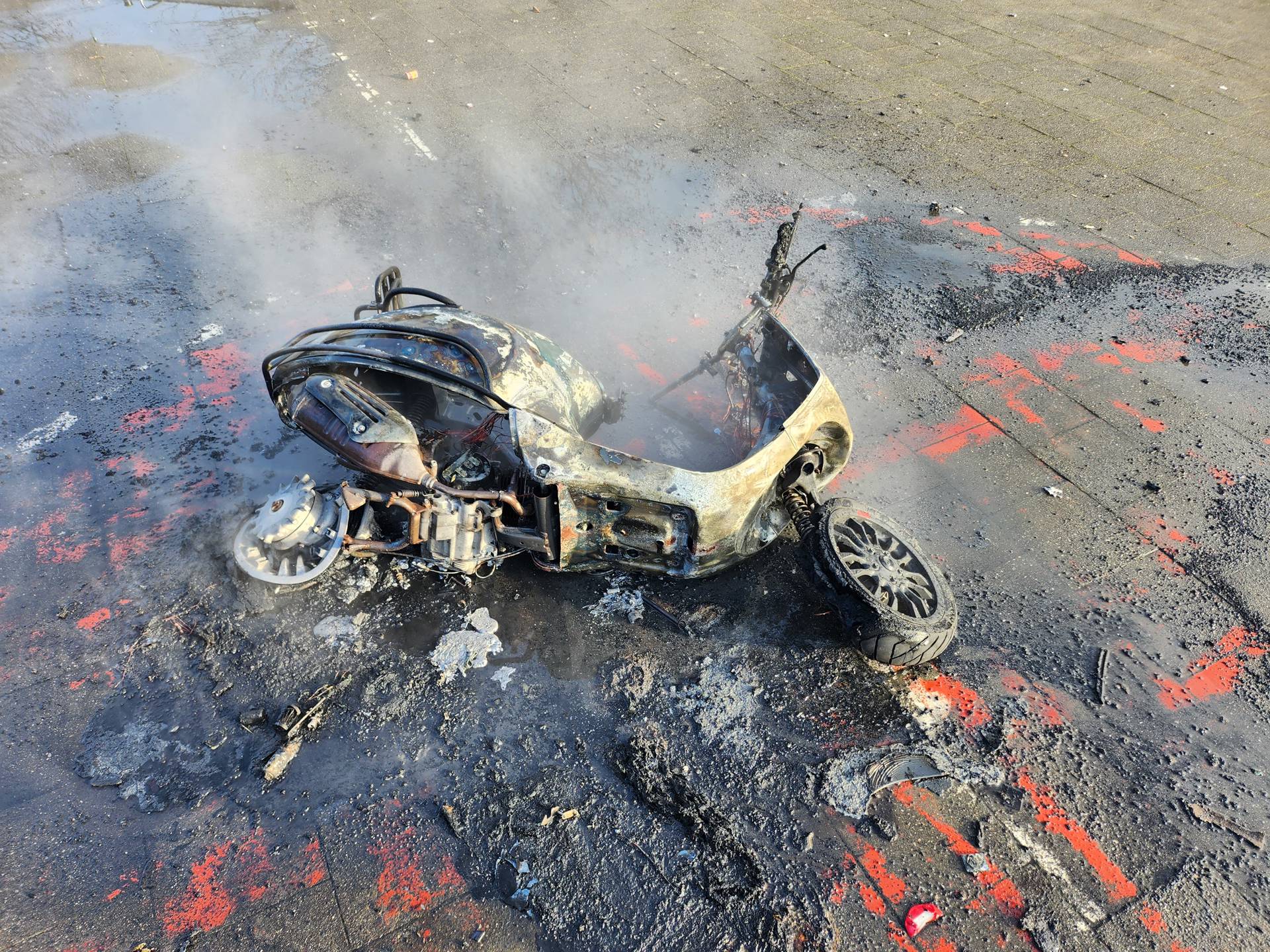 Scooter in brand gestoken door groep jongens