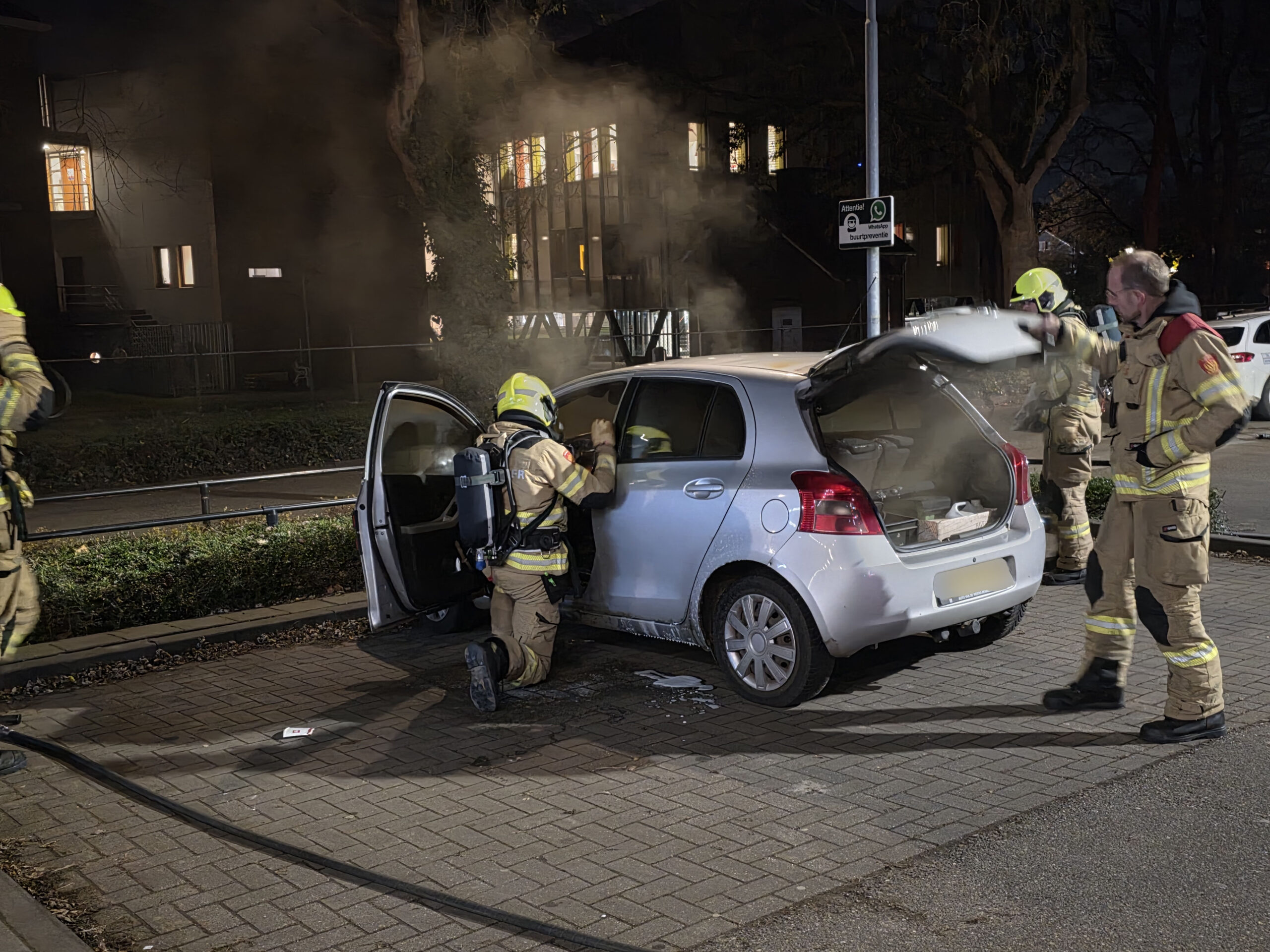 Geparkeerde auto in lichterlaaie; omstanders grijpen in