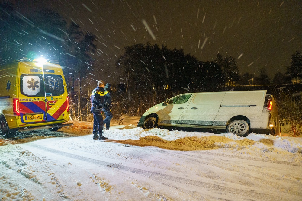 Pakketbezorger glijdt van de weg en belandt in greppel