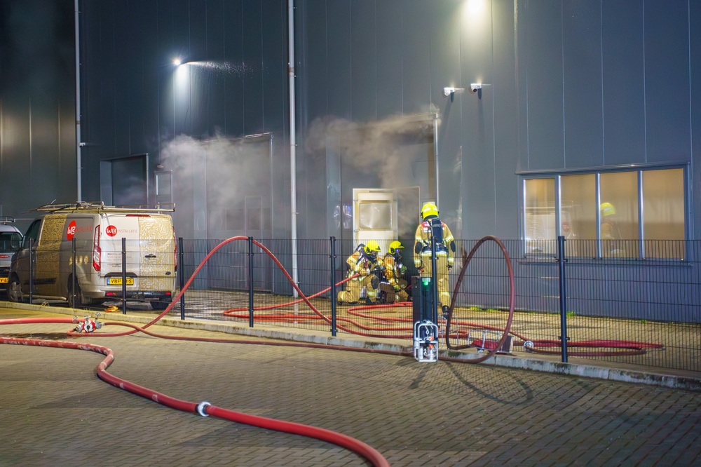 Grote brandweerinzet door brand in vuilcontainer in bedrijfspand