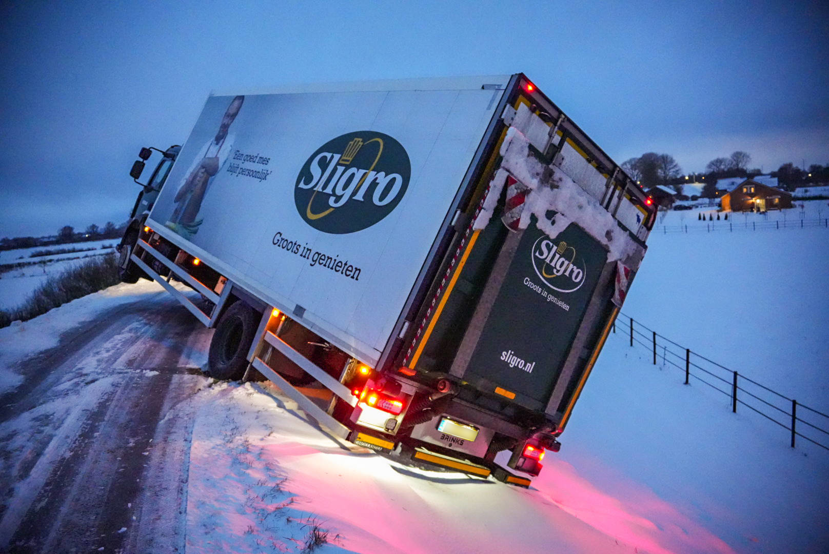 Vrachtwagen helt gevaarlijk over dijk