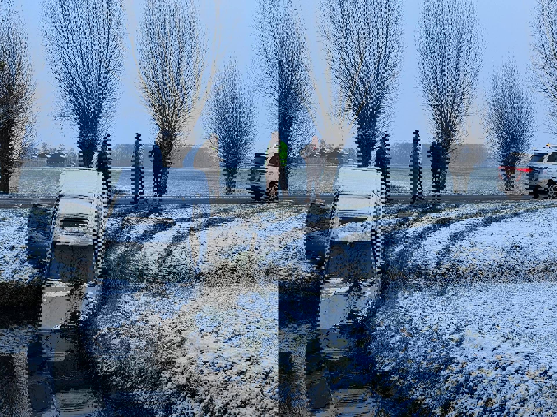 Auto glijdt door gladheid in sloot