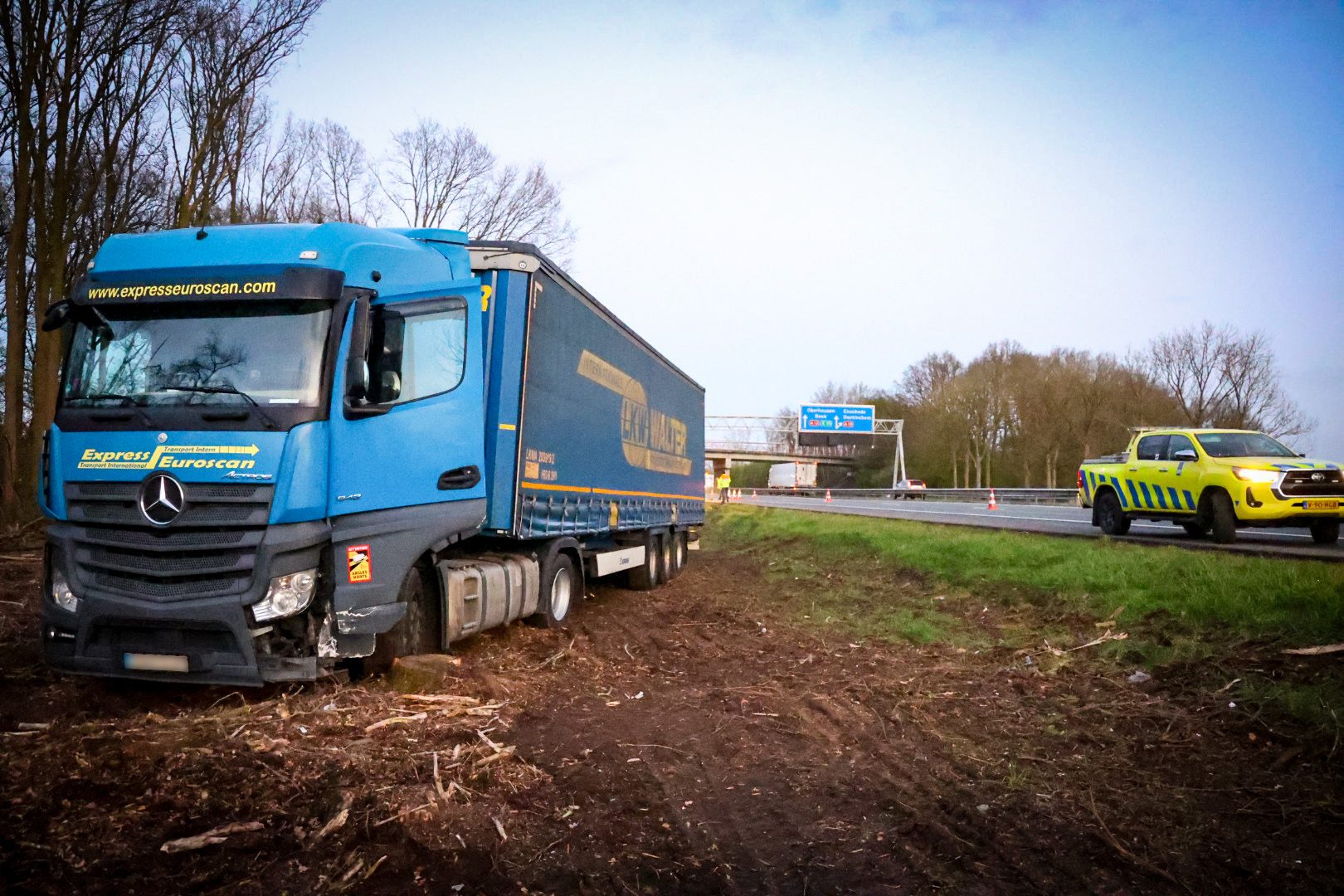Vrachtwagen belandt naast snelweg in berm en lekt diesel