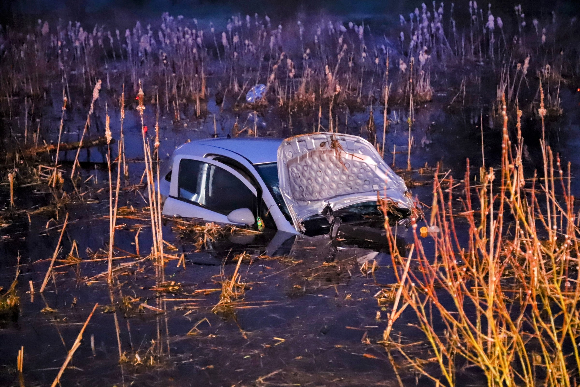 Auto rijdt van dijk en belandt in water, bestuurder gewond