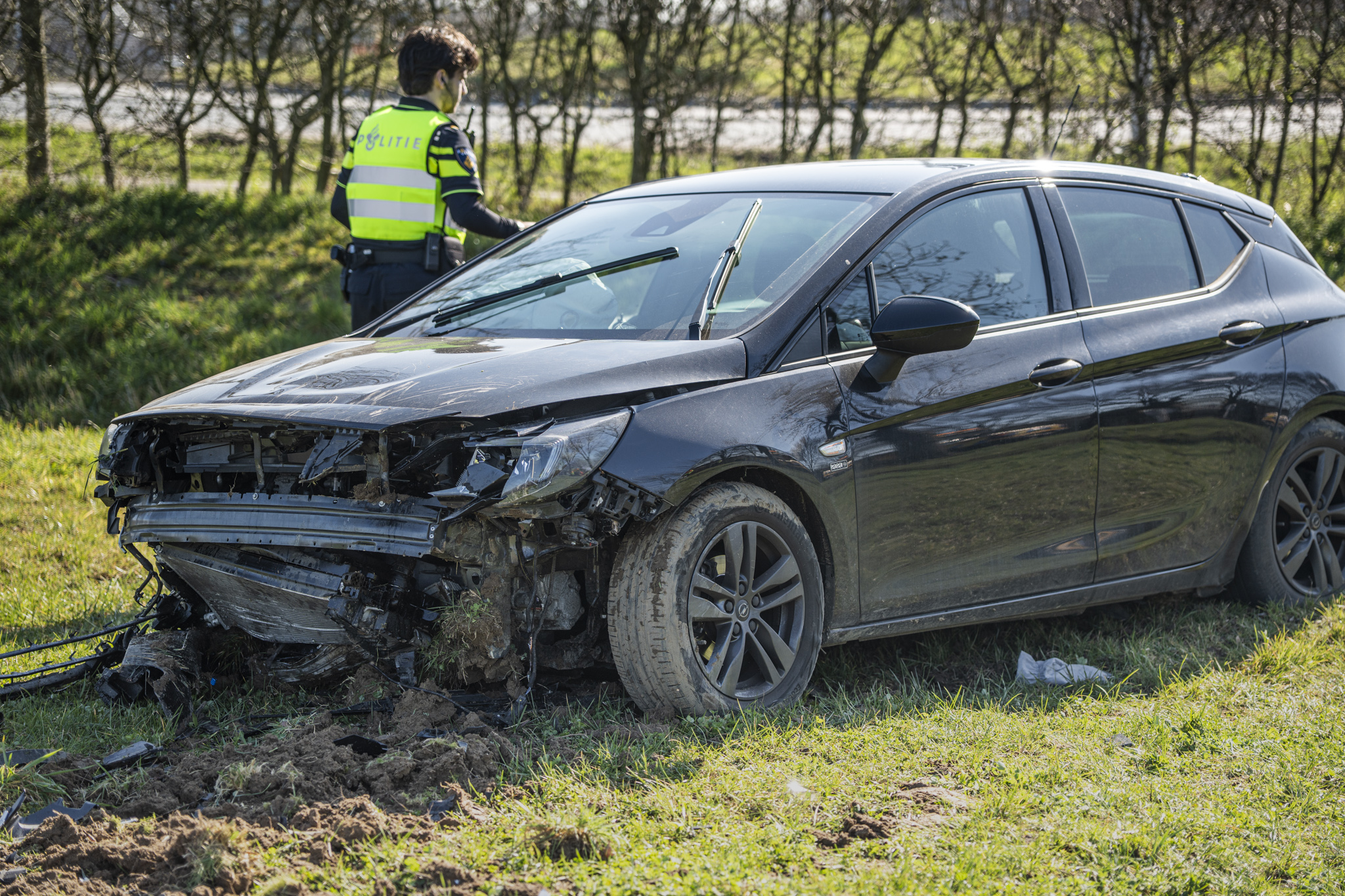 Auto raakt van rotonde en belandt in weiland