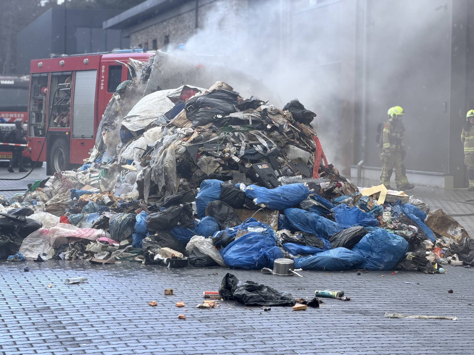 Vuilniswagen lost rokende lading op weg na brandmelding