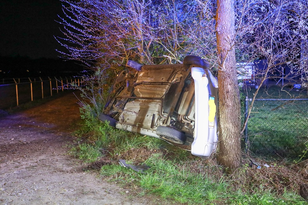 Auto op z’n kant tegen boom, bestuurder gewond