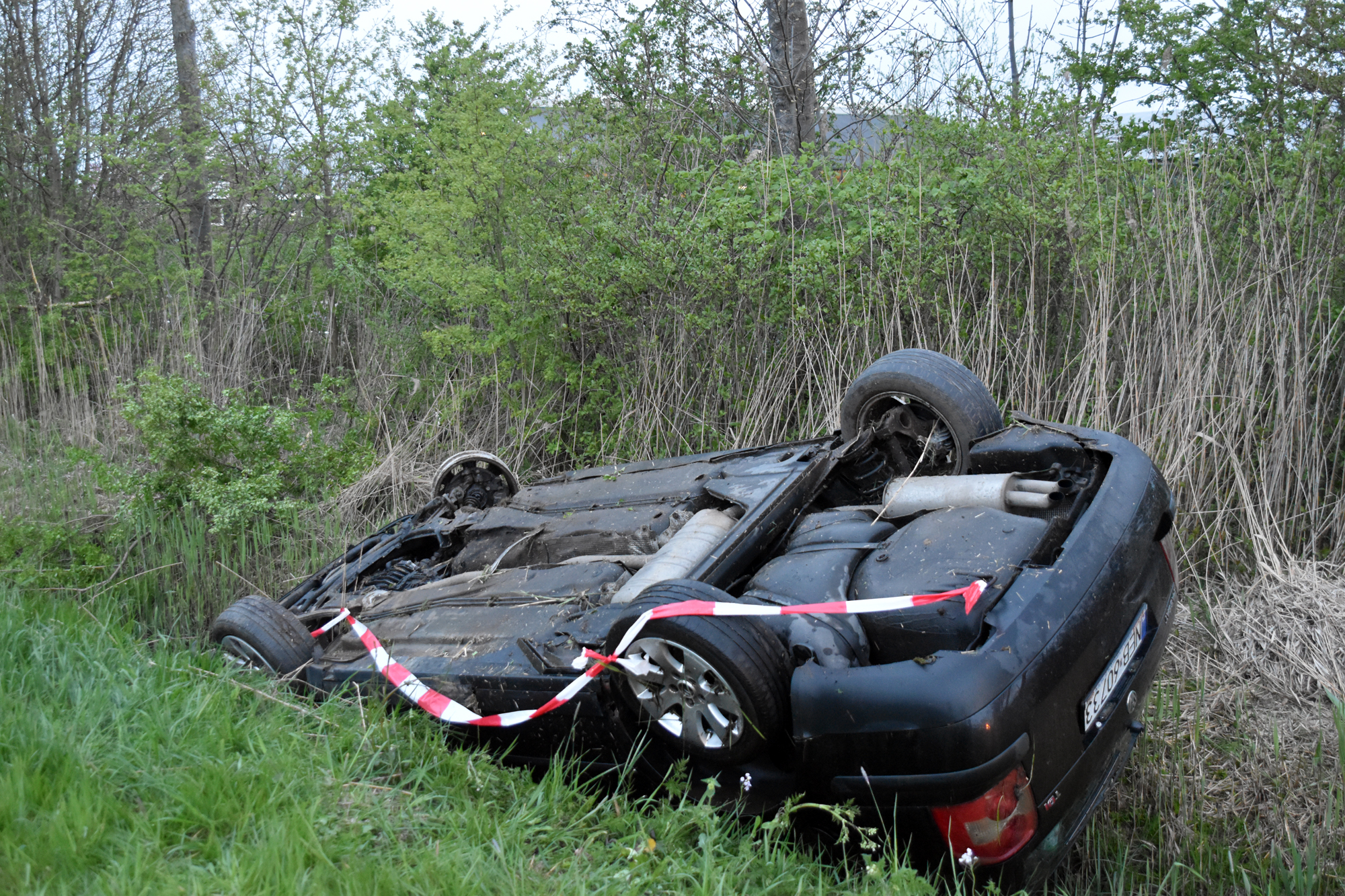 Auto op z’n kop in sloot, inzittenden met schrik vrij