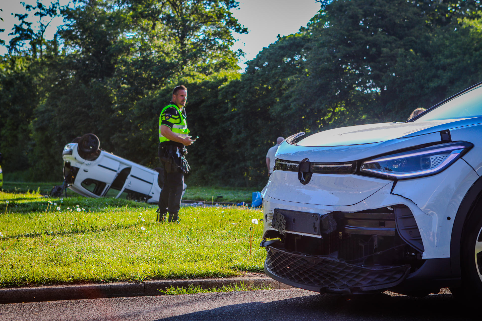 Twee auto’s botsen op kruispunt, wagen slaat over de kop