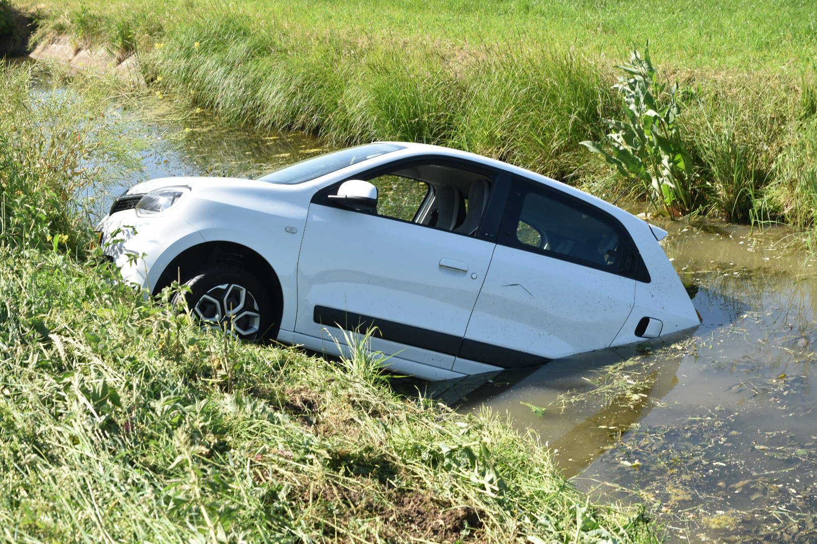 Auto belandt in sloot, bestuurster komt met schrik vrij