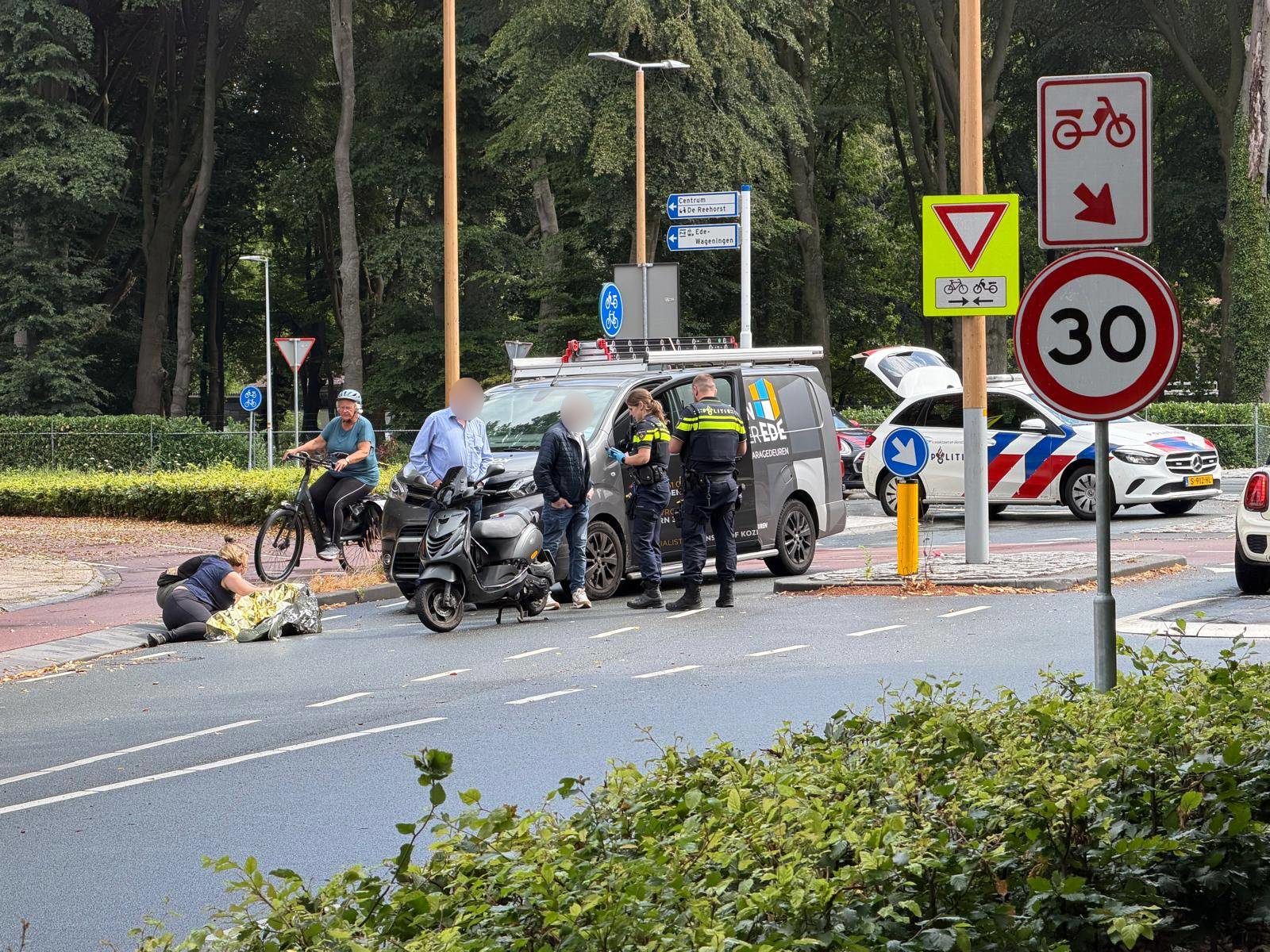 Scooter en bestelauto botsen op rotonde