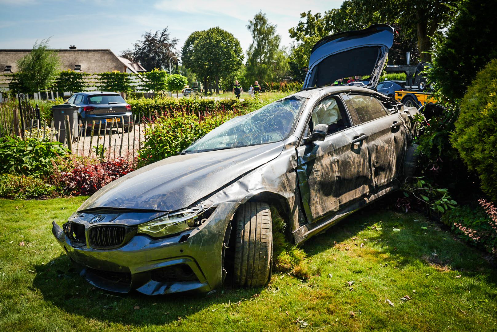 BMW slaat over de kop en eindigt in tuin