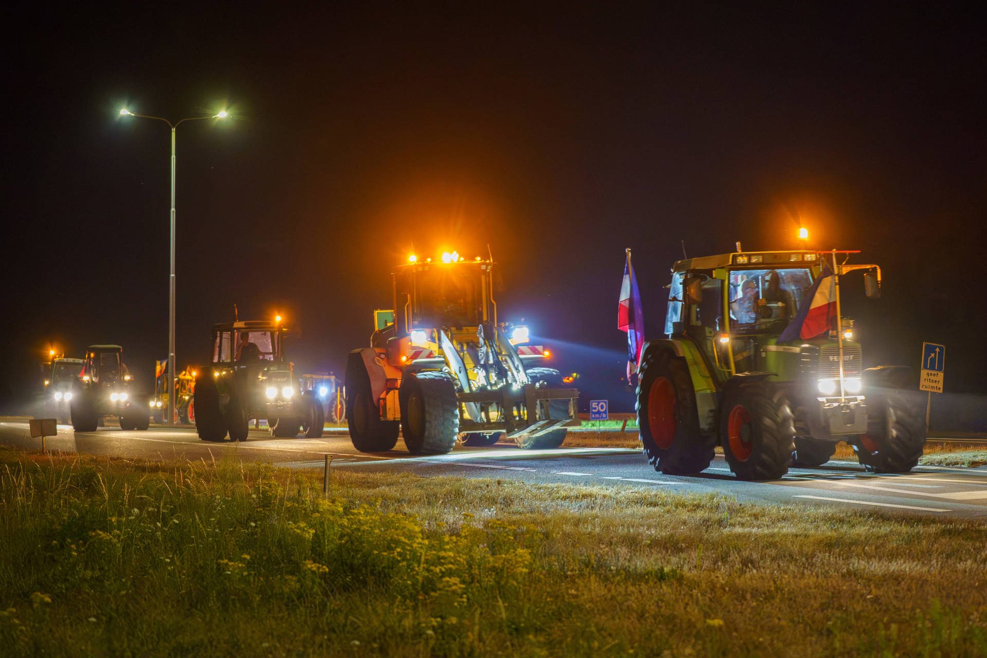 Boeren blokkeren brug en rijden in colonne over snelweg bij boerenprotest