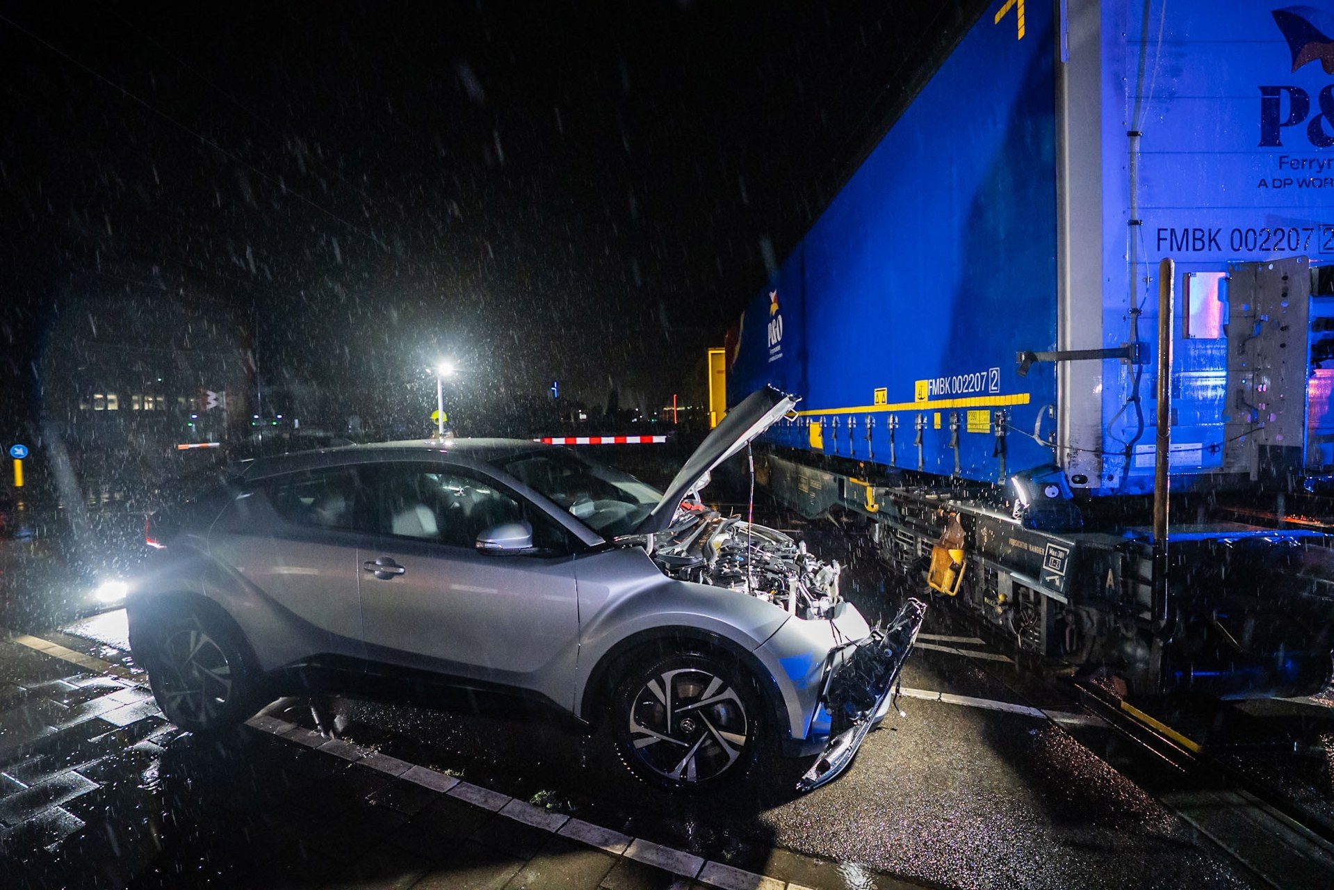 Auto botst op spoorwegovergang tegen goederentrein, hulpdiensten ter plaatse