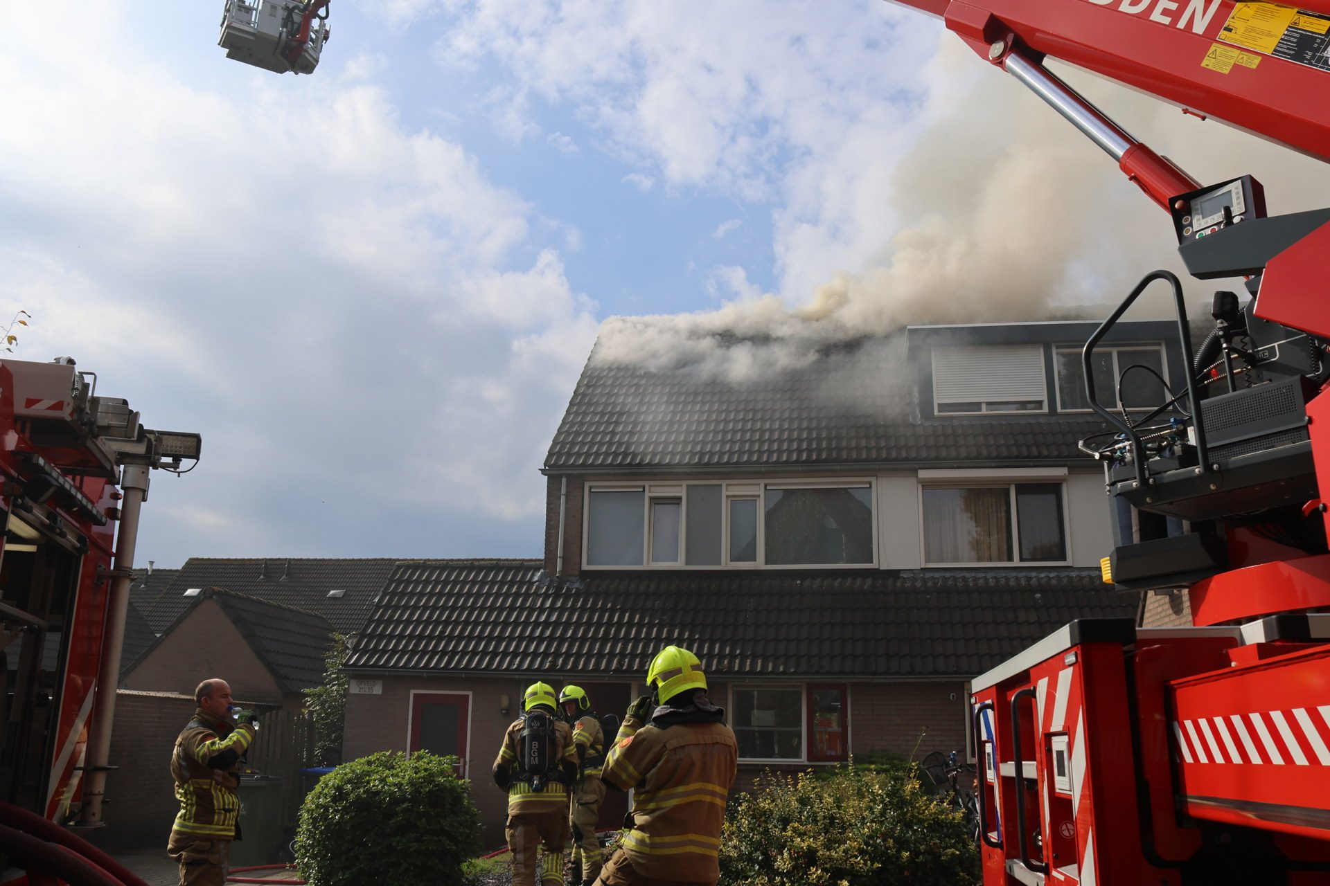 Vlammen slaan uit dak bij woningbrand